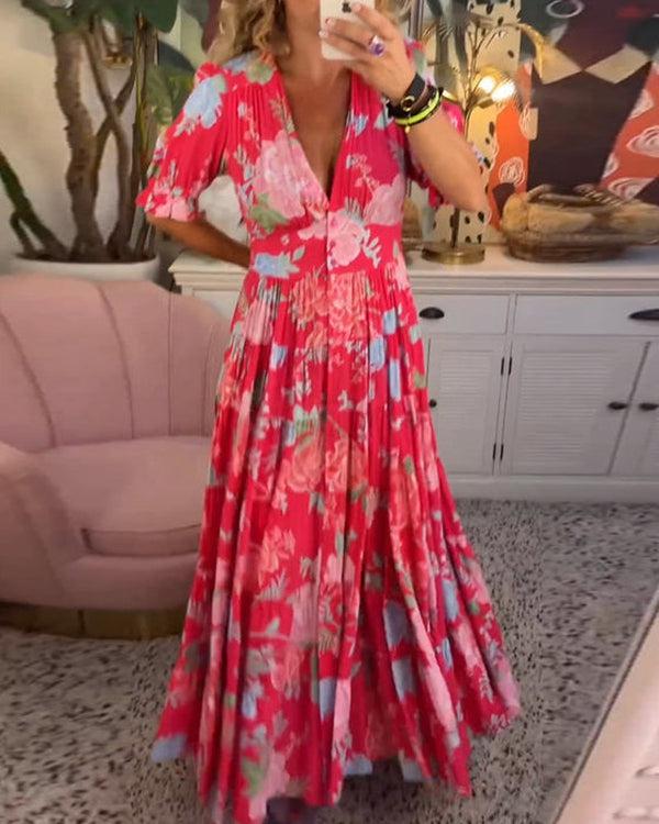 A woman wearing the Dawn bold floral maxi dress with a flowing full-length skirt at a garden gathering.