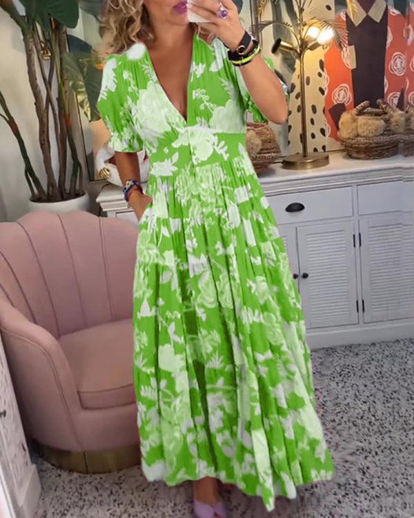A woman wearing the Dawn bold floral maxi dress with a flowing full-length skirt at a garden gathering.