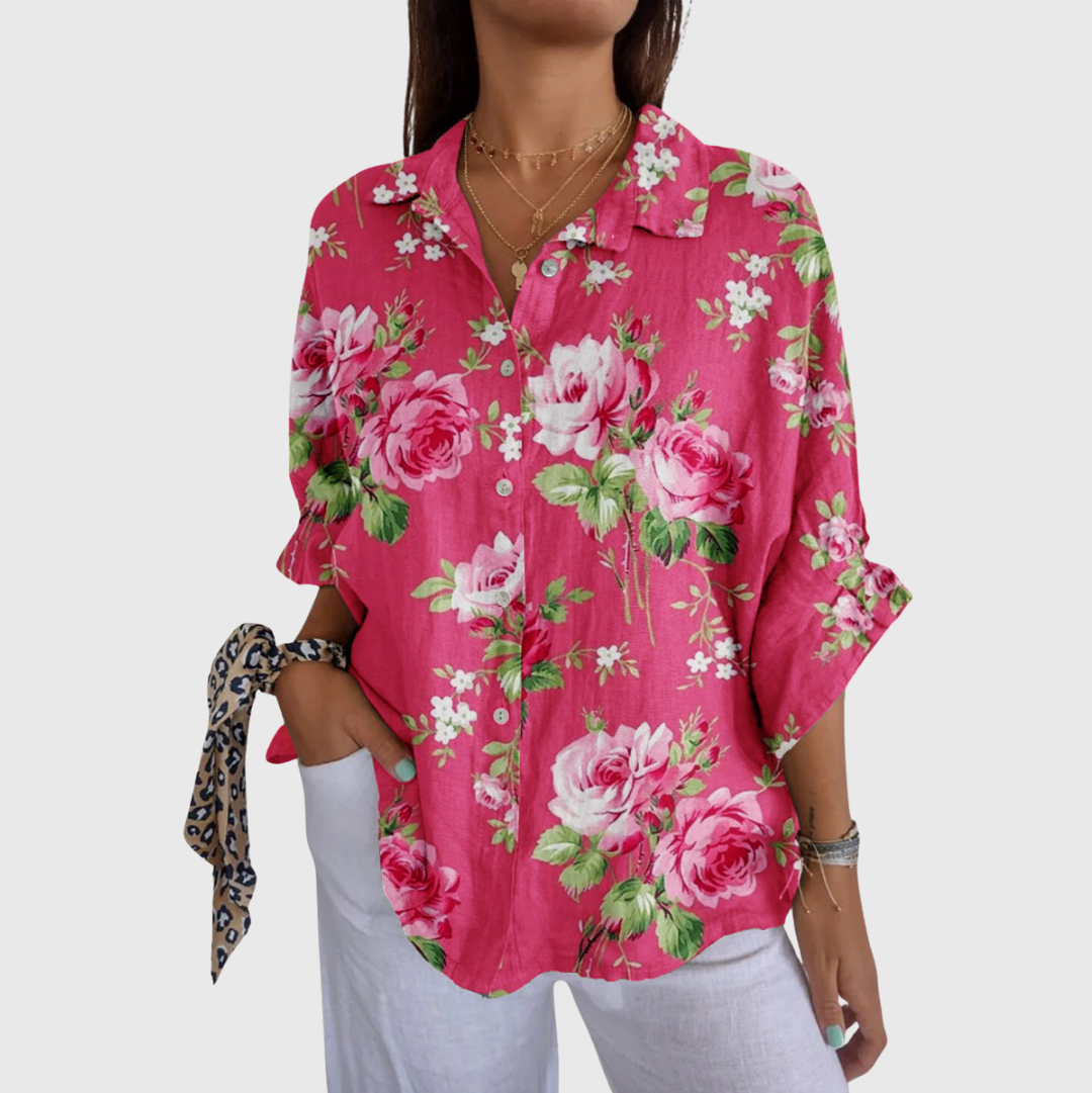 A woman wearing a colourful printed blouse with a relaxed, flowing cut, looking cheerful and comfortable.