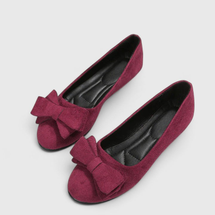 A pair of olive-green ballet flats with a soft bow at the rounded toe.
