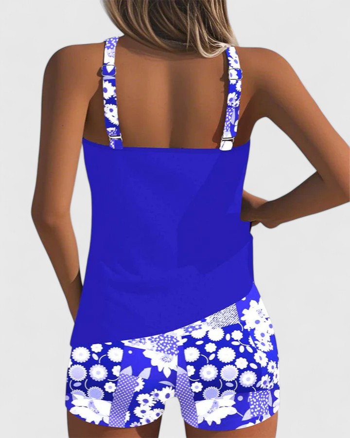 A woman wearing a blue tankini set with a loose tank top and matching floral-print shorts.