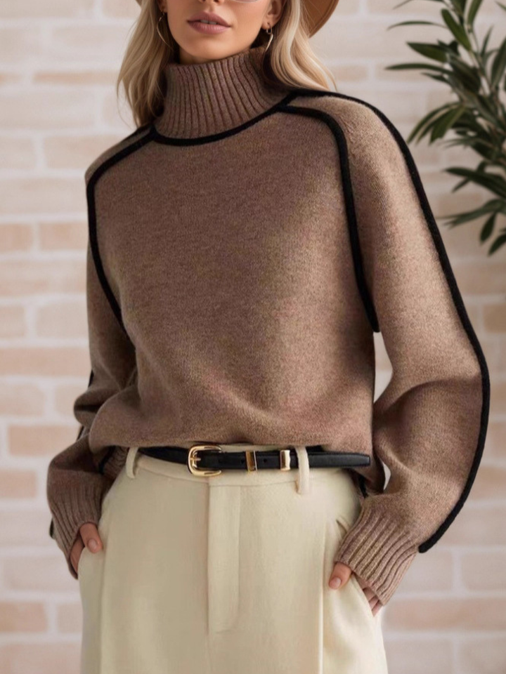 A woman wearing a funnel neck sweater with contrast piping, styled with pants for a smart-casual look.