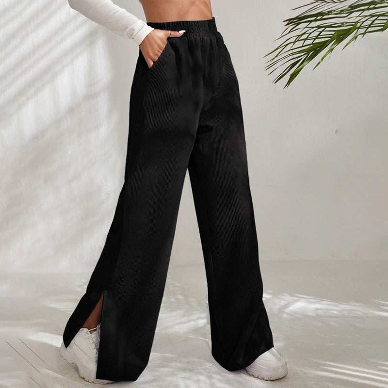 Woman wearing wide-leg ribbed joggers with a fitted top, relaxed at home.