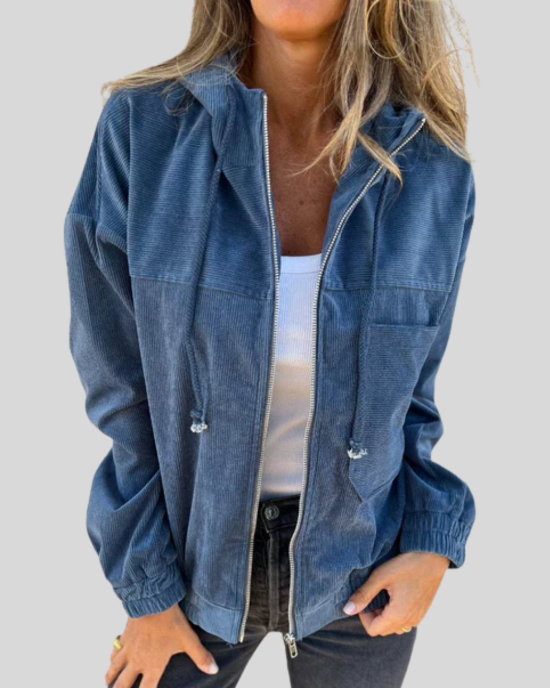 A woman wearing a blue zip-up hooded jacket with a soft ribbed texture and long sleeves.
