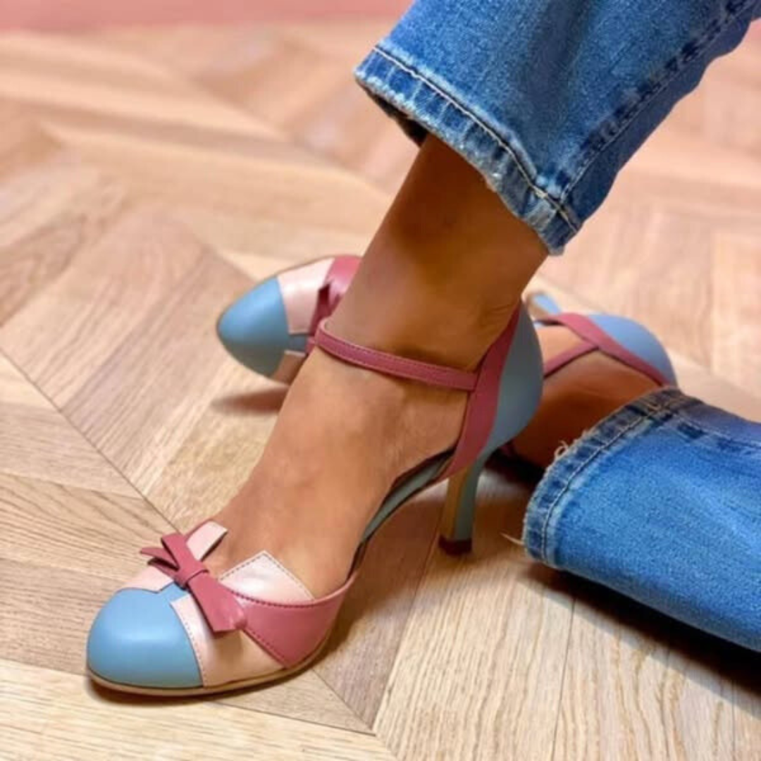 A woman in pastel colourblock pumps with an ankle strap, dressed for a wedding.