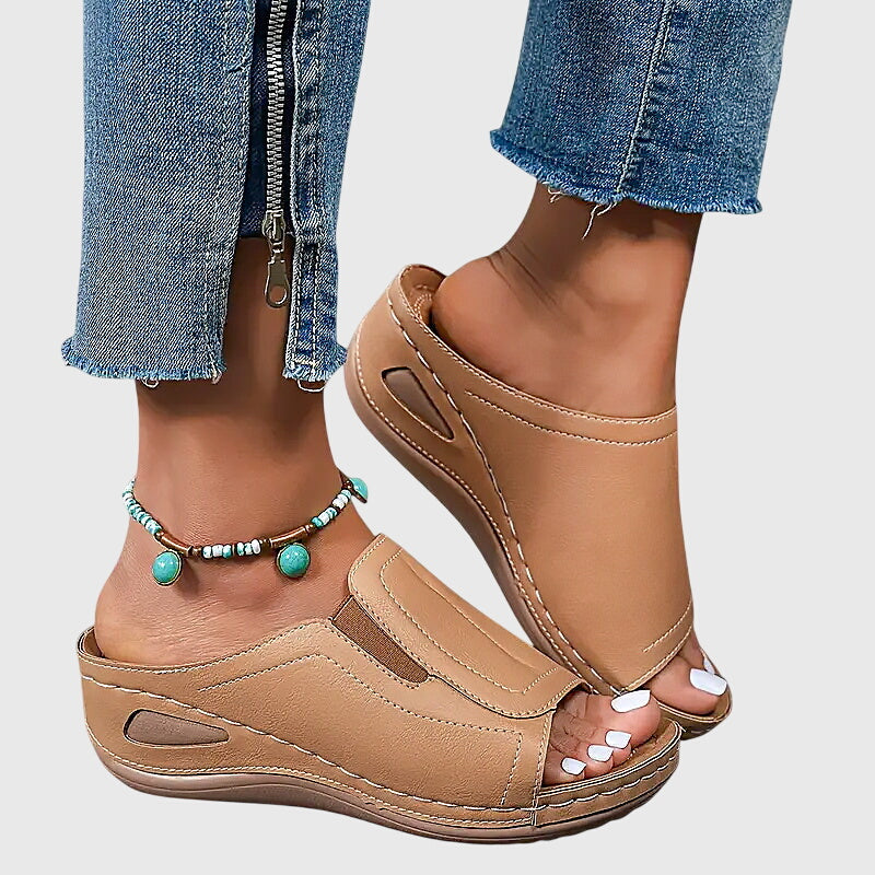Tan open-toe wedge slides with a smooth one-piece upper and a cushioned wedge sole.