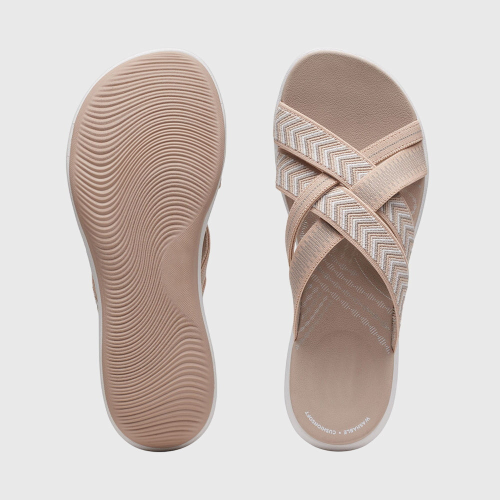 A woman in beige lightweight soft sandals walking easily on a sunny path, feet cushioned and supported.