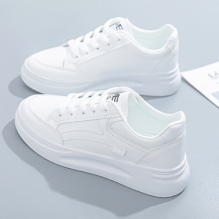A woman in crisp white light comfort sneakers paired with jeans.