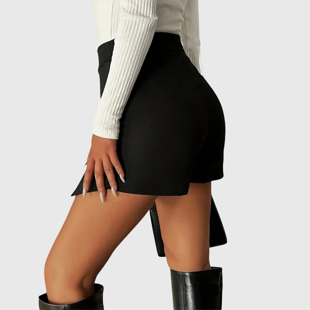 A woman wearing a sleek high-waisted black mini skirt with a front slit.