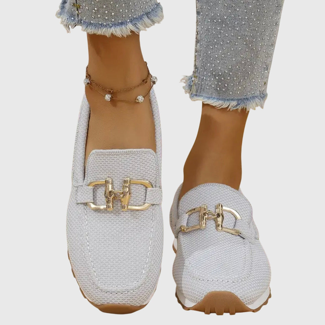A woman in smart-casual orthopaedic loafer sneakers with a subtle golden detail.