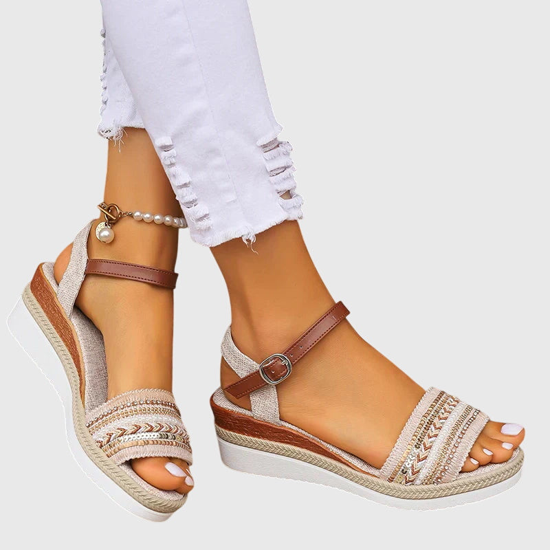 A woman walking easily in lightweight modern sandals in a soft white and brown finish.