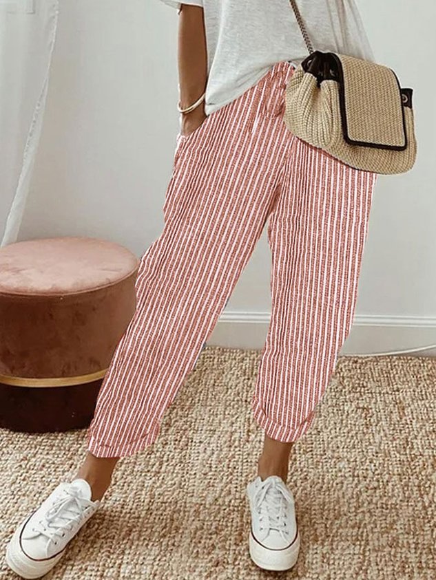 A woman wearing flowing elegant pants with a soft elastic waist and deep pockets.