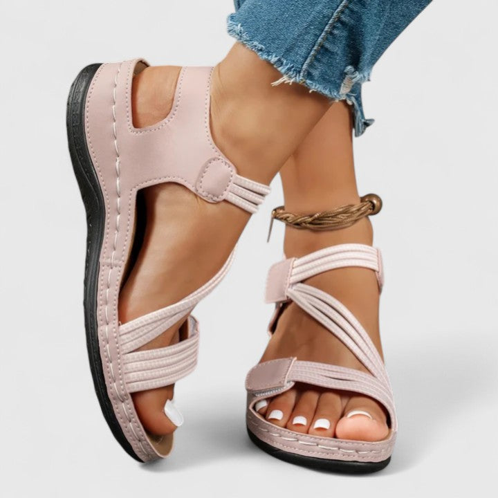 A woman wearing soft adjustable comfort sandals with a summer outfit, looking relaxed and content.