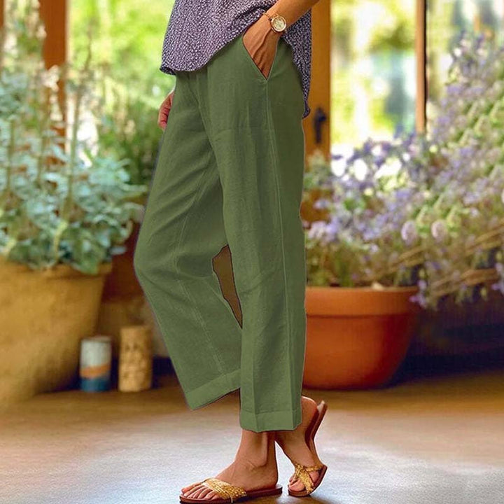 Woman wearing relaxed straight-leg pants with a soft top, standing in soft daylight.