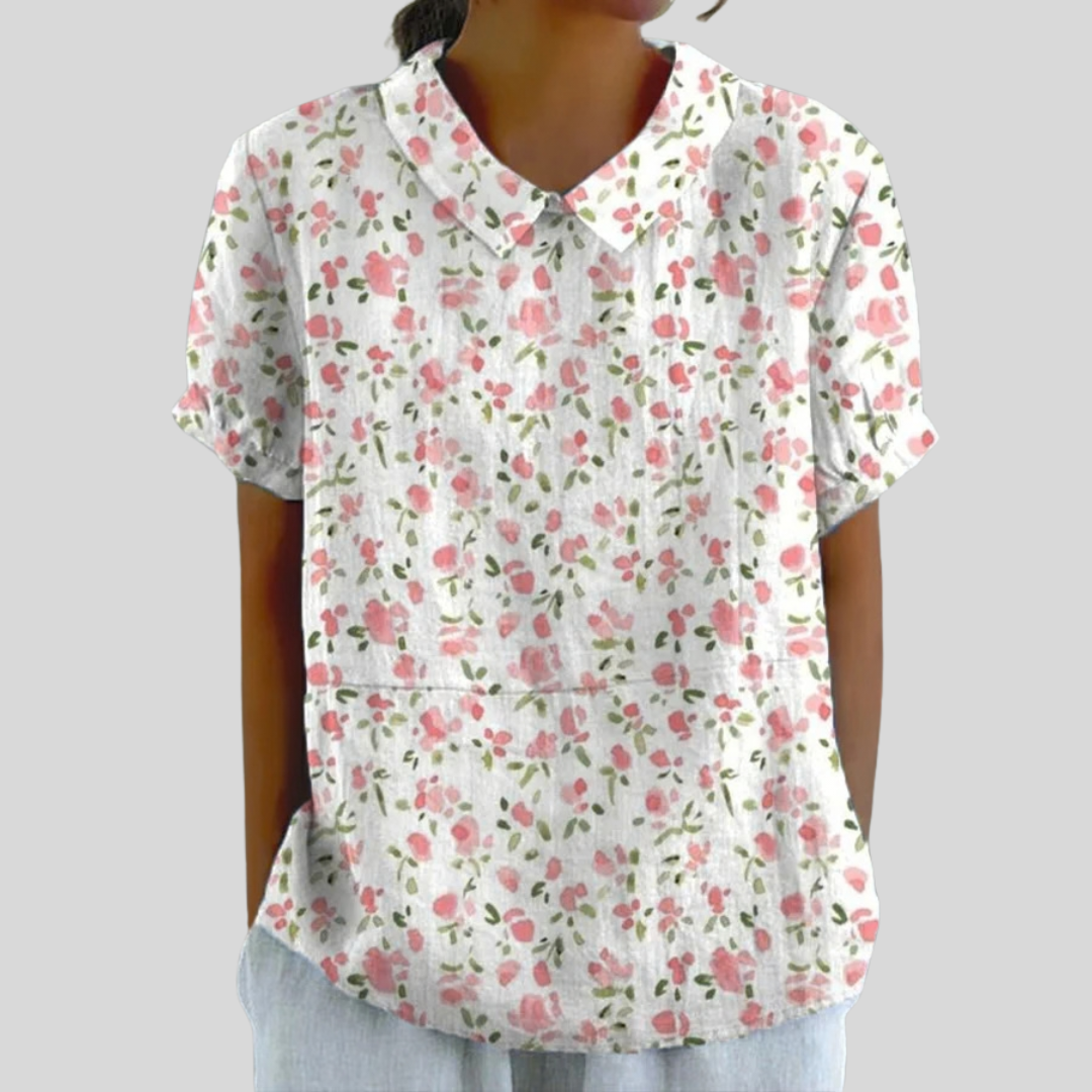 A woman wearing an elegant floral top with a polo collar, looking feminine and comfortable.