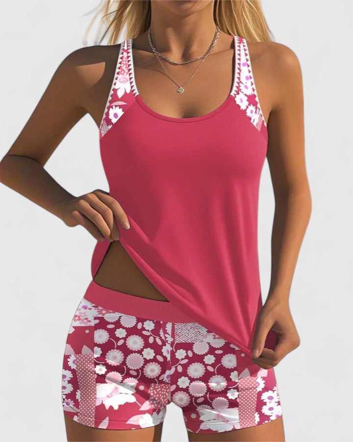 A woman wearing a blue tankini set with a loose tank top and matching floral-print shorts.