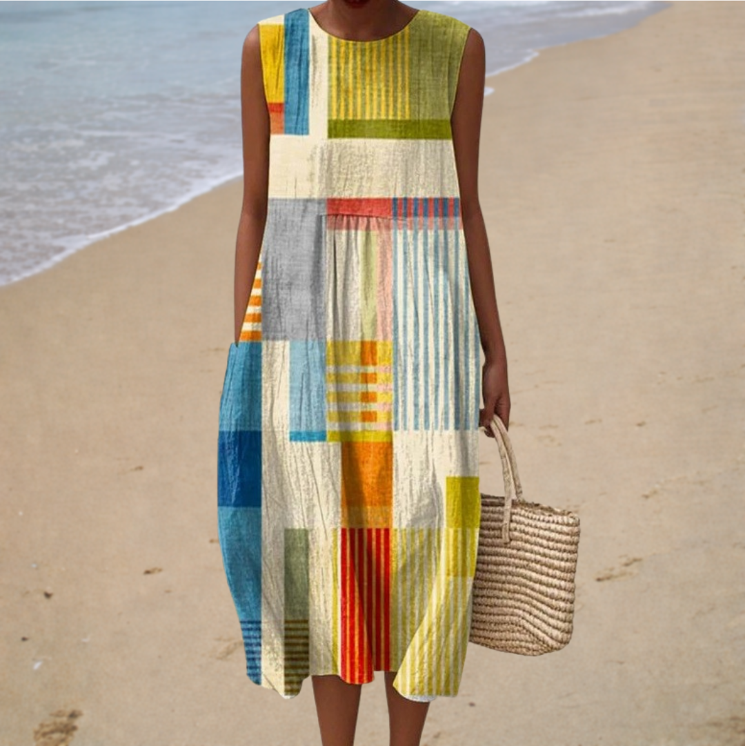 A woman wearing an airy sleeveless patterned dress on a warm summer day.