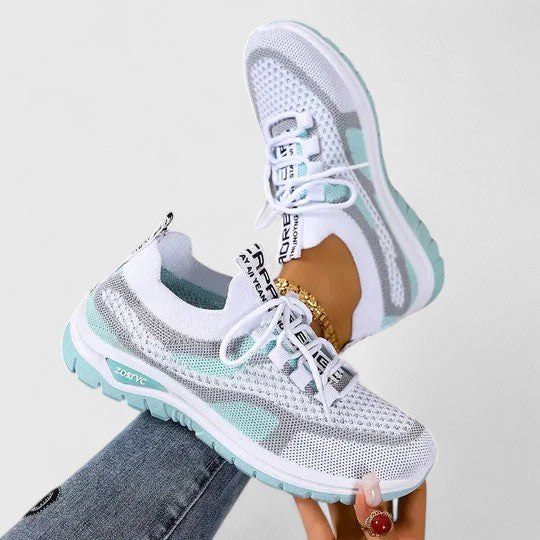 A woman lacing up light, breathable orthopaedic sneakers before a walk.