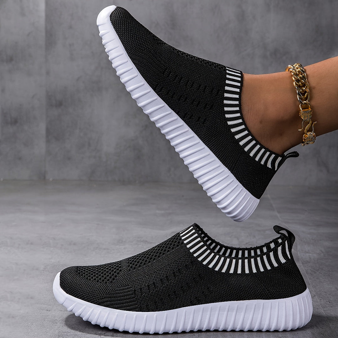 A woman slipping on ultralight sock-style sneakers that hug the foot.