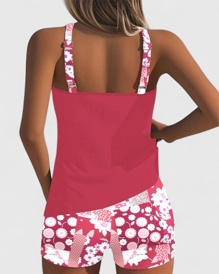 A woman wearing a blue tankini set with a loose tank top and matching floral-print shorts.