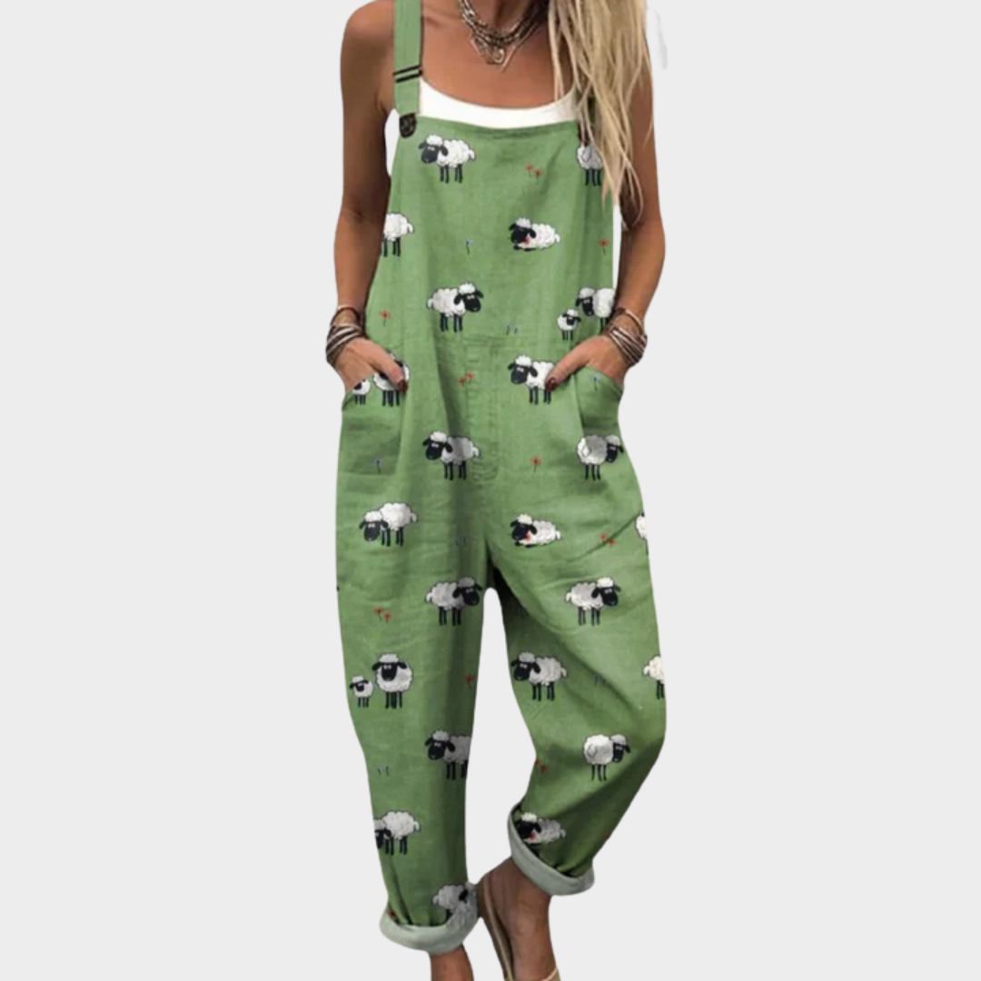 A woman wearing fresh green overalls printed with charming little sheep, with adjustable straps.