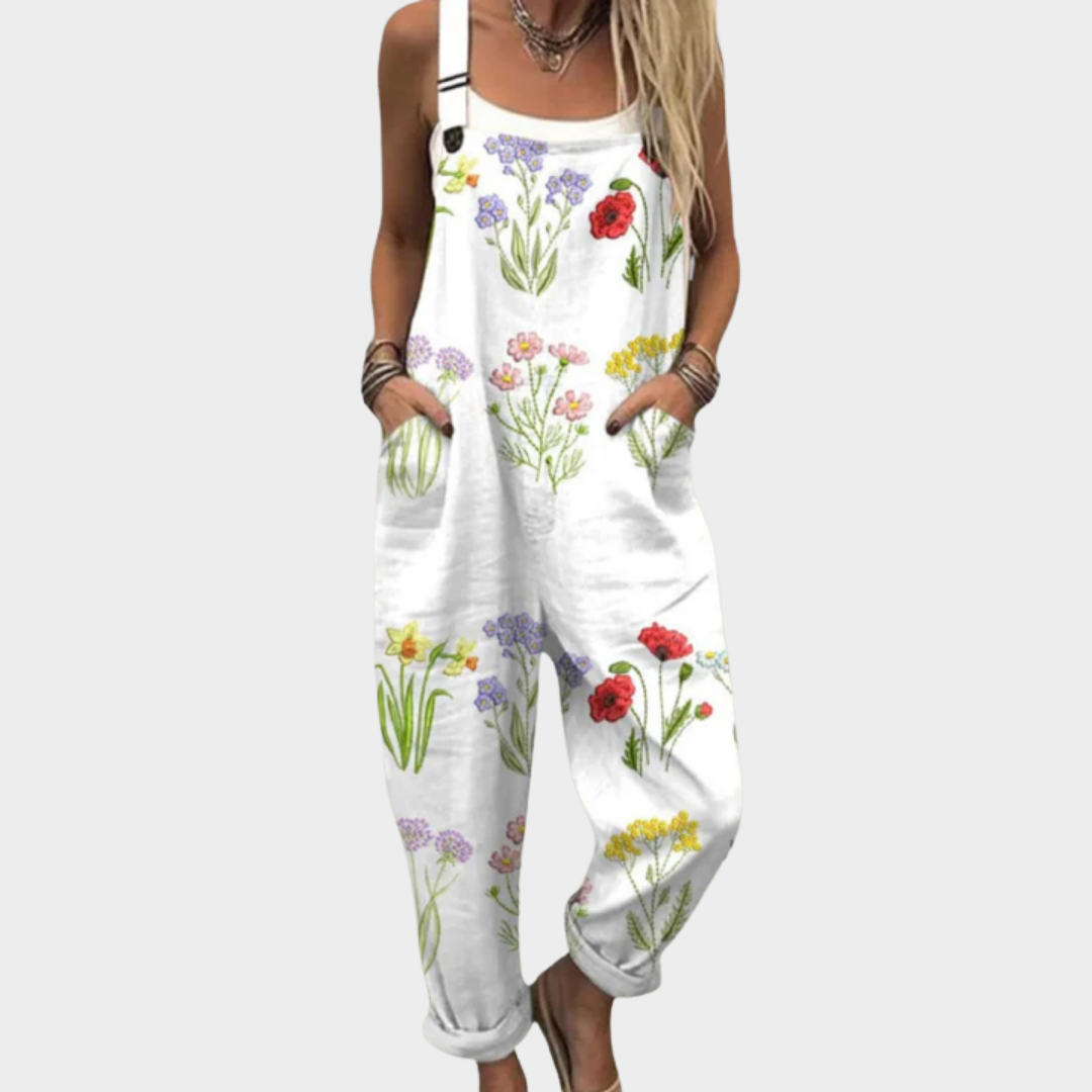 Woman wearing white overalls with a colourful wildflower print of poppies and daisies, light and cheerful.