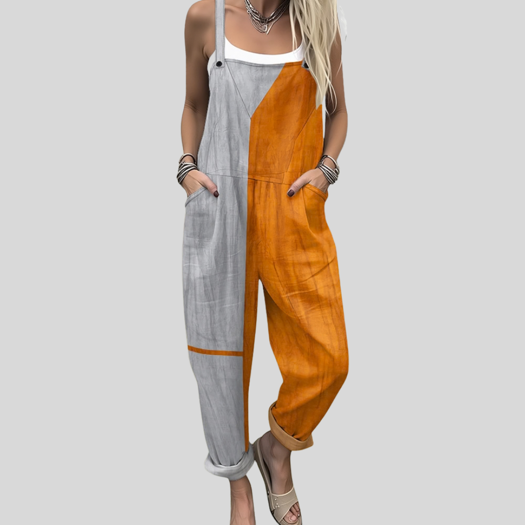A woman wearing colour-block overalls in grey and orange, standing confidently in a bright setting.