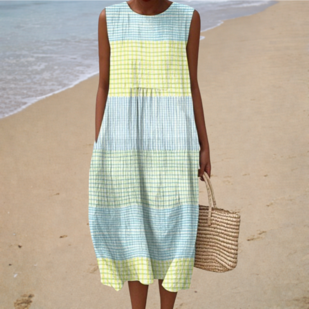 A woman wearing a soft sleeveless printed summer dress, relaxed and elegant on a warm day.