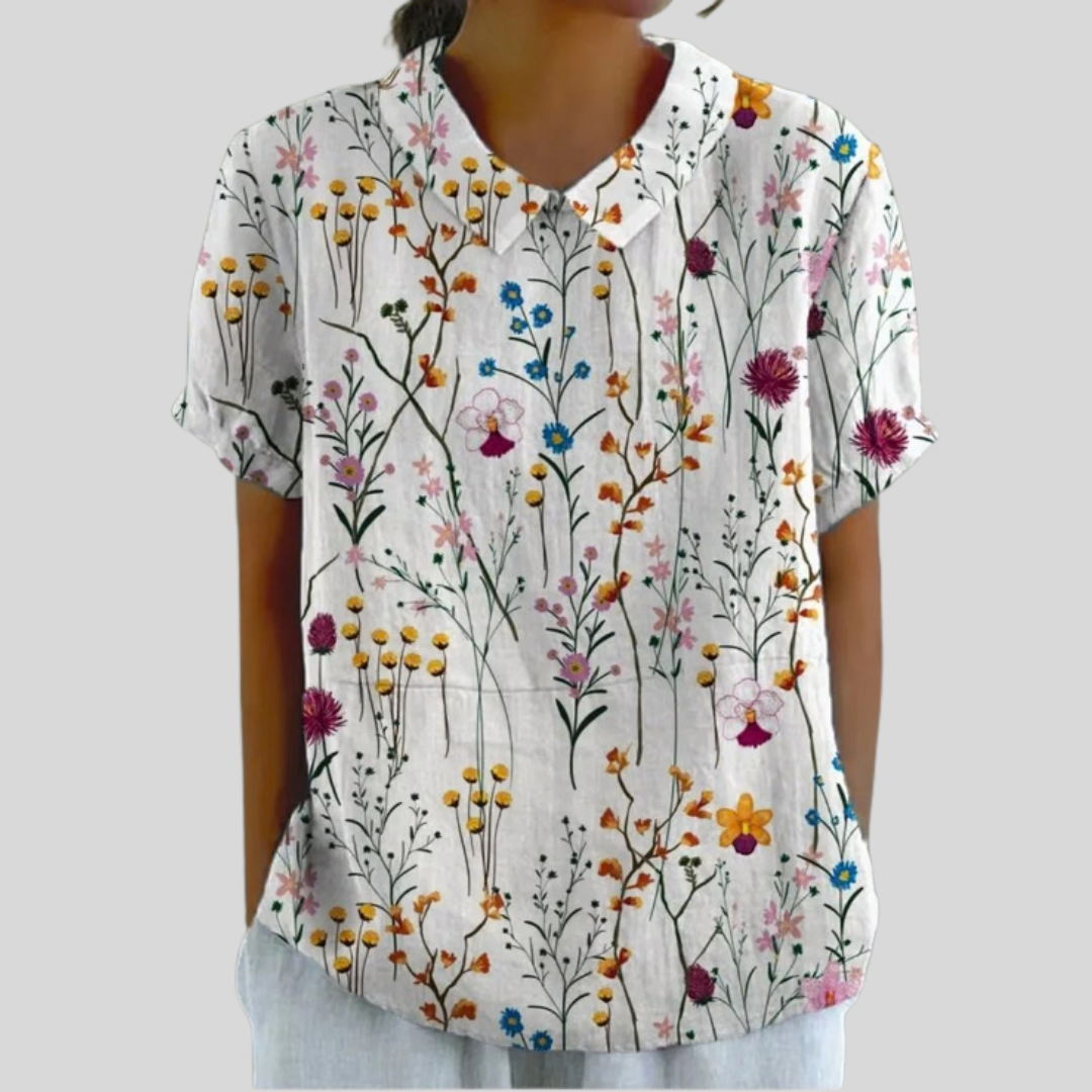 A woman wearing an everyday floral top with a polo collar, looking effortlessly elegant.