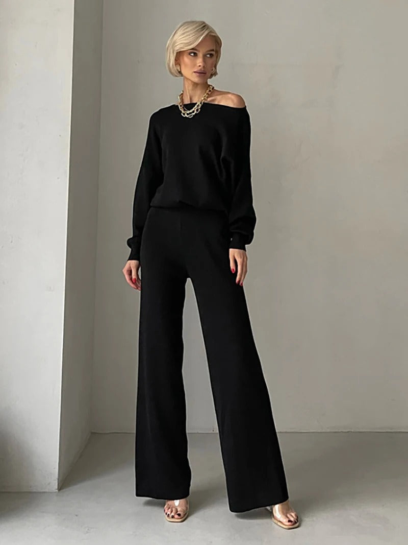 A woman wearing an off-shoulder draped top with wide-leg pants