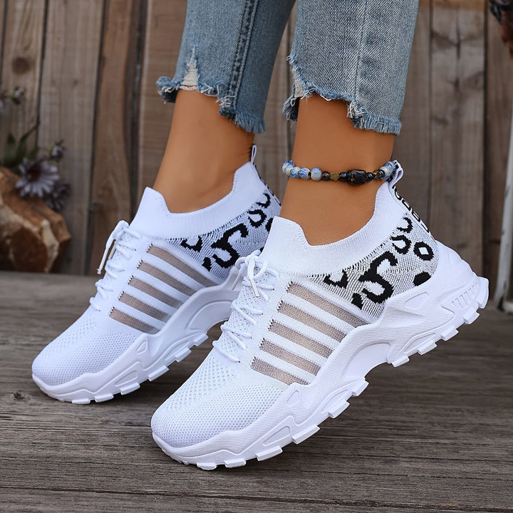 A woman walking in light, breathable comfort sneakers on a warm day.
