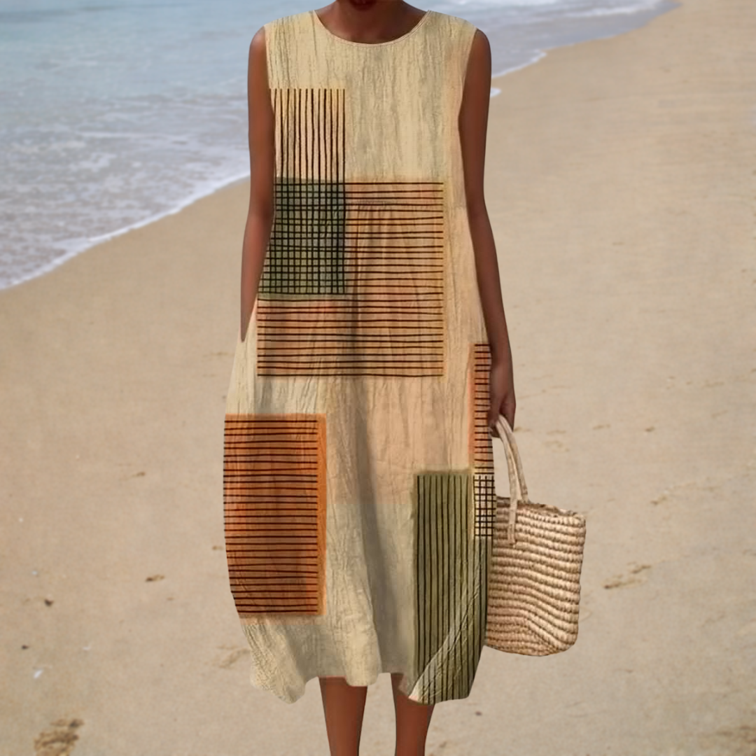 A woman wearing a flowing sleeveless printed summer dress on a warm, sunny day.
