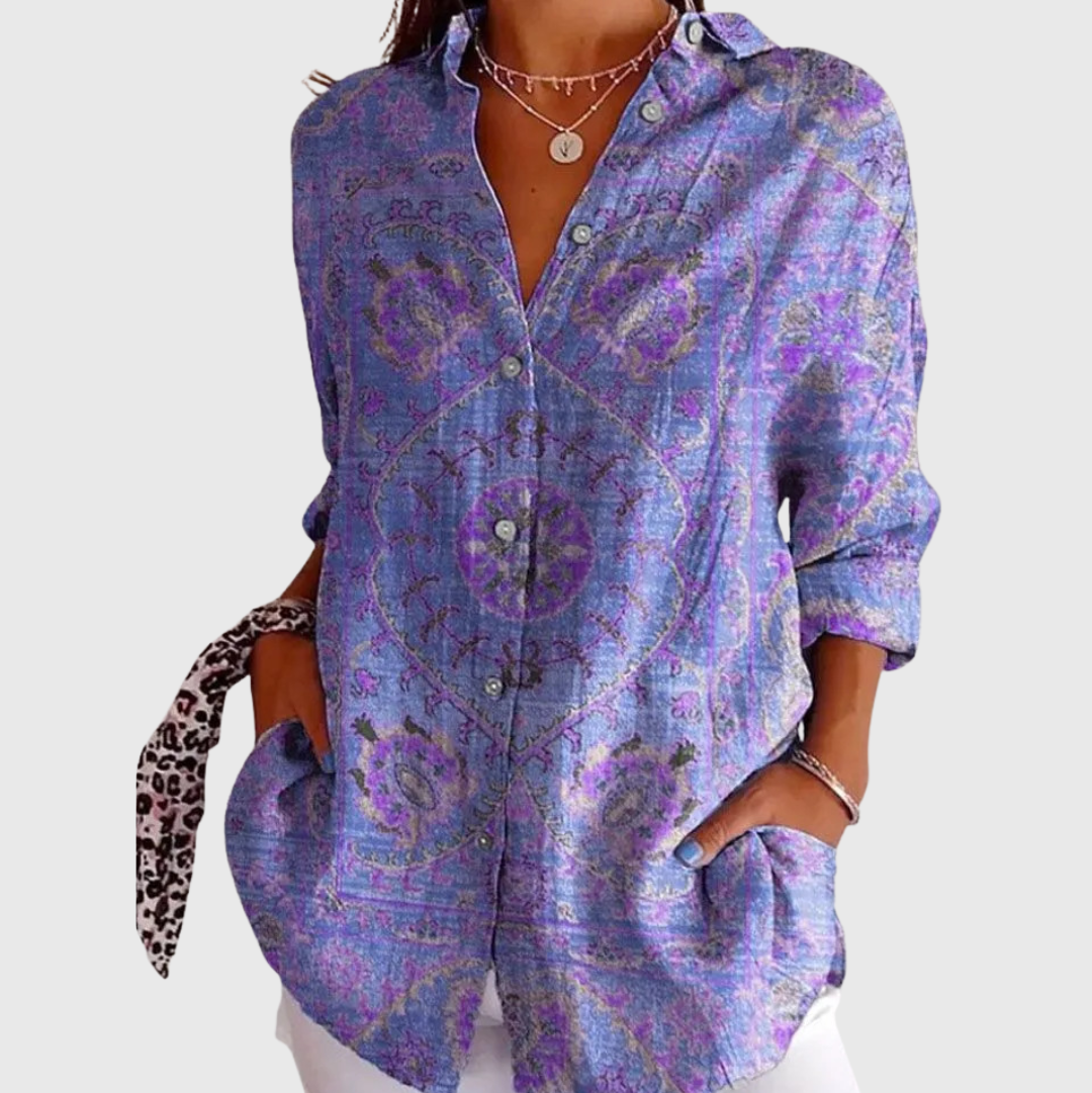 A woman wearing a loose colourful printed blouse with adjustable sleeves, styled with a skirt for a comfortable day out.