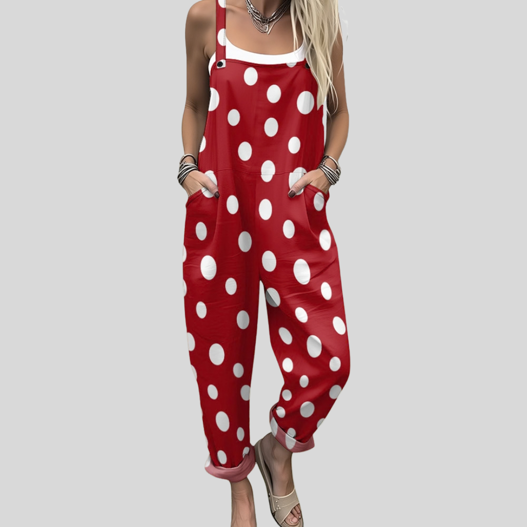 Woman wearing bold red overalls with big white polka dots, standing cheerfully in a retro-inspired look.