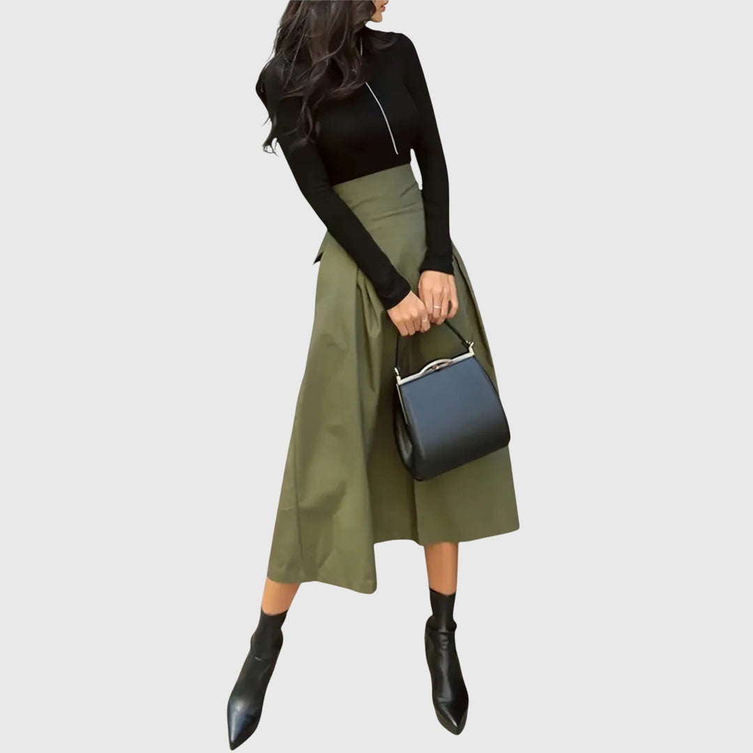 A woman wearing a flared green midi skirt with a belt detail at the waist.