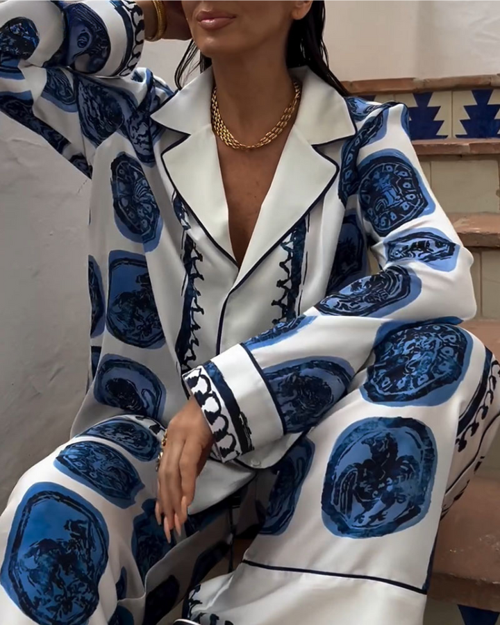 A woman wearing a blue-and-white printed open-collar shirt and matching straight-leg pants on a warm summer day