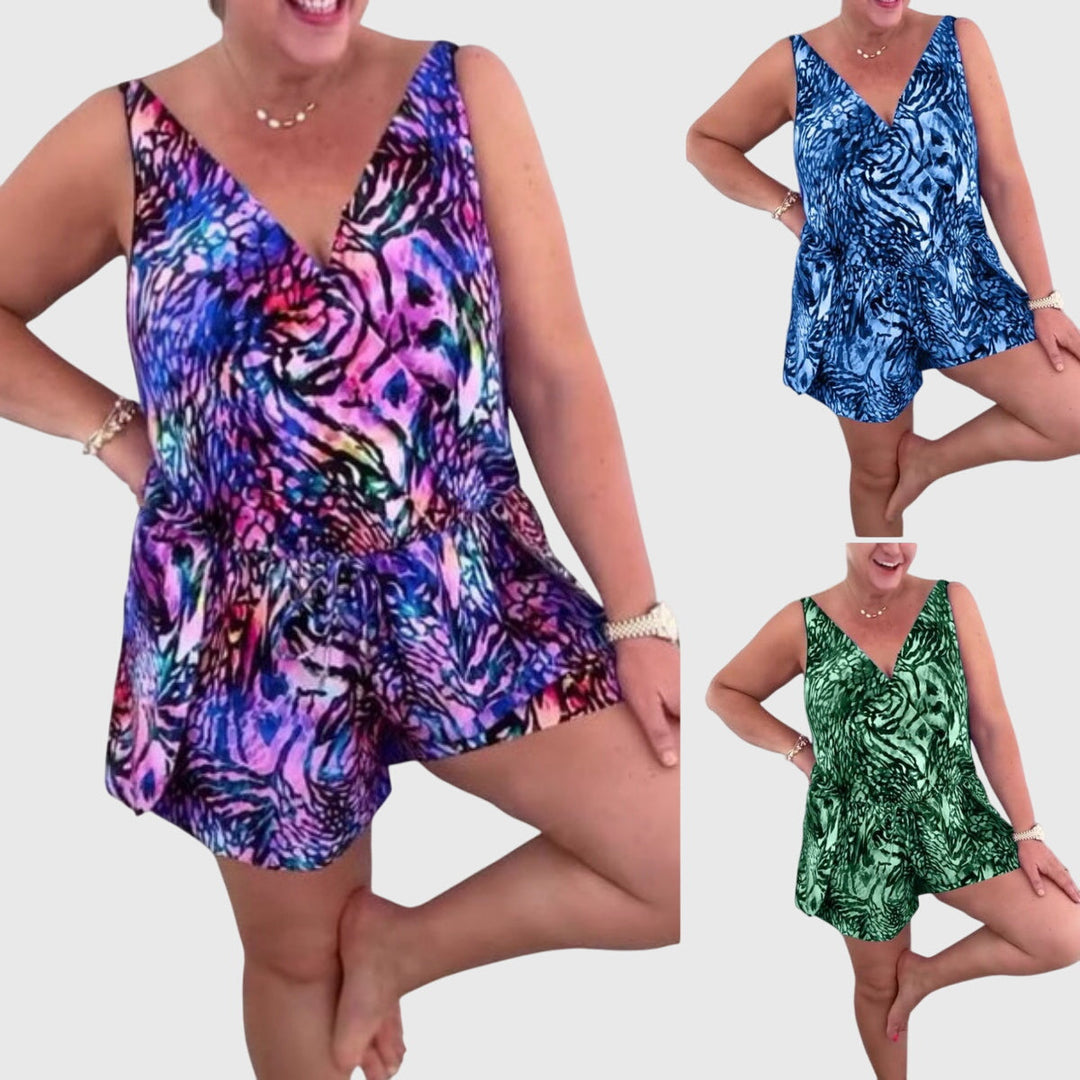 A woman in a blue printed swim playsuit with a flowing top and shorts, relaxed by the pool.