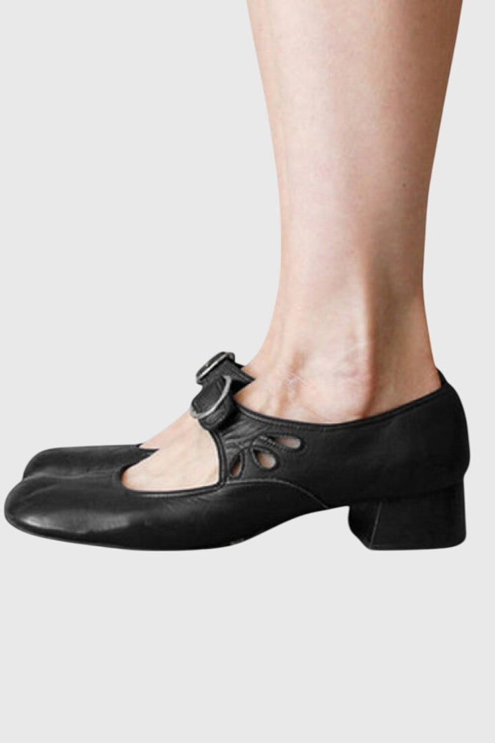 A woman wearing low heel Mary Janes with an adjustable strap, dressed for work.