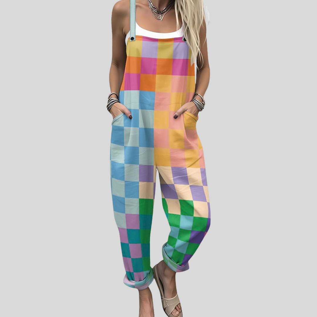 A woman wearing overalls in a soft pastel check of pink, lilac, mint and yellow, with adjustable straps.