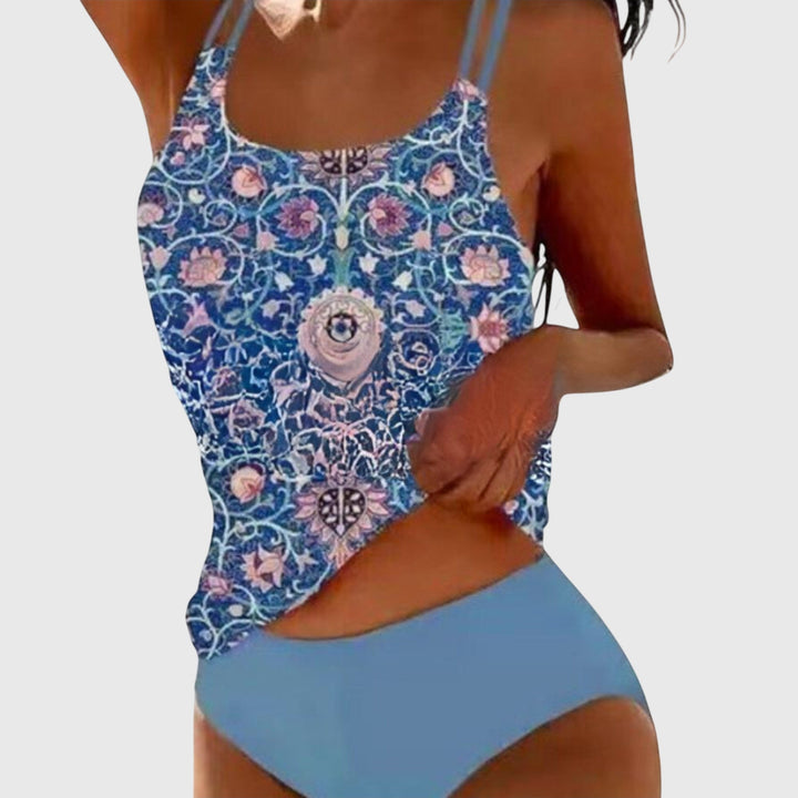 A woman by the sea in a coordinated printed two-piece swimsuit set, relaxed in the summer sun.