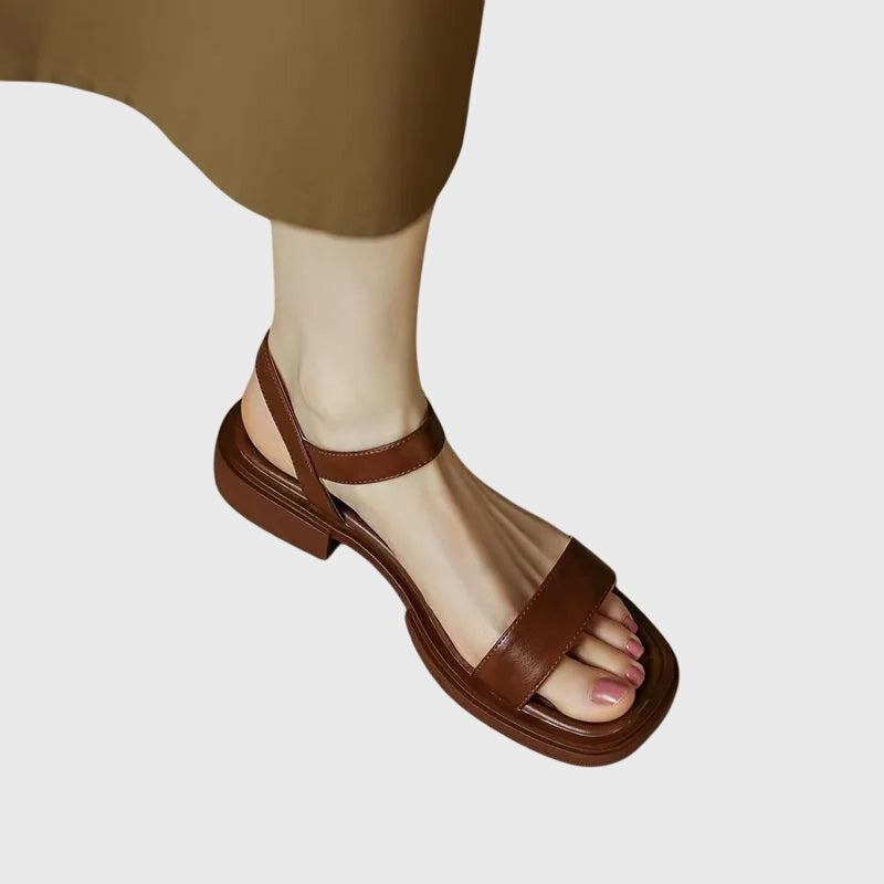 A woman in white square-toe ankle-strap sandals dressed for a summer brunch.