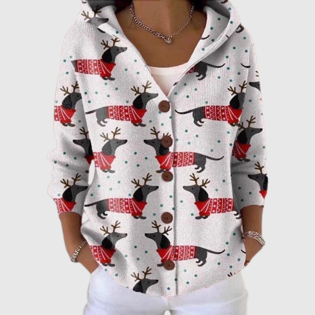 A woman wearing a white hooded button cardigan printed with dachshunds in red sweaters and antlers.