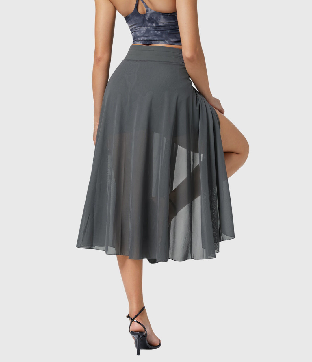 A woman in an elegant high-waisted flowing skirt, styled for a versatile day-to-evening look.