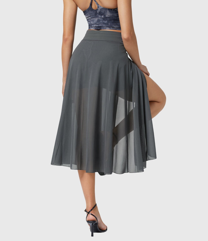 A woman in an elegant high-waisted flowing skirt, styled for a versatile day-to-evening look.