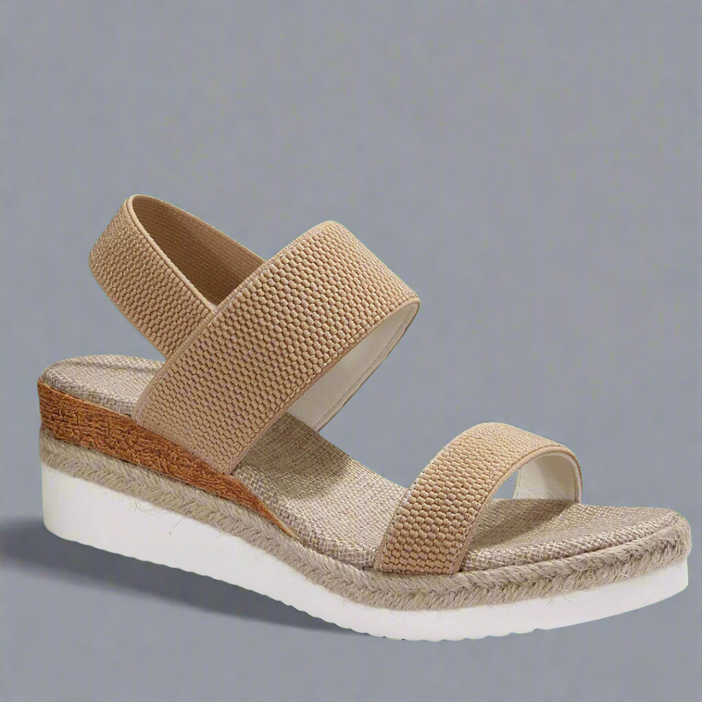 A woman wearing pink platform comfort sandals with a broad, cushioned footbed at an evening event.