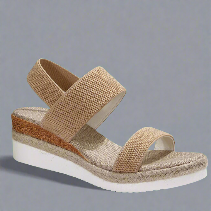 A woman wearing pink platform comfort sandals with a broad, cushioned footbed at an evening event.