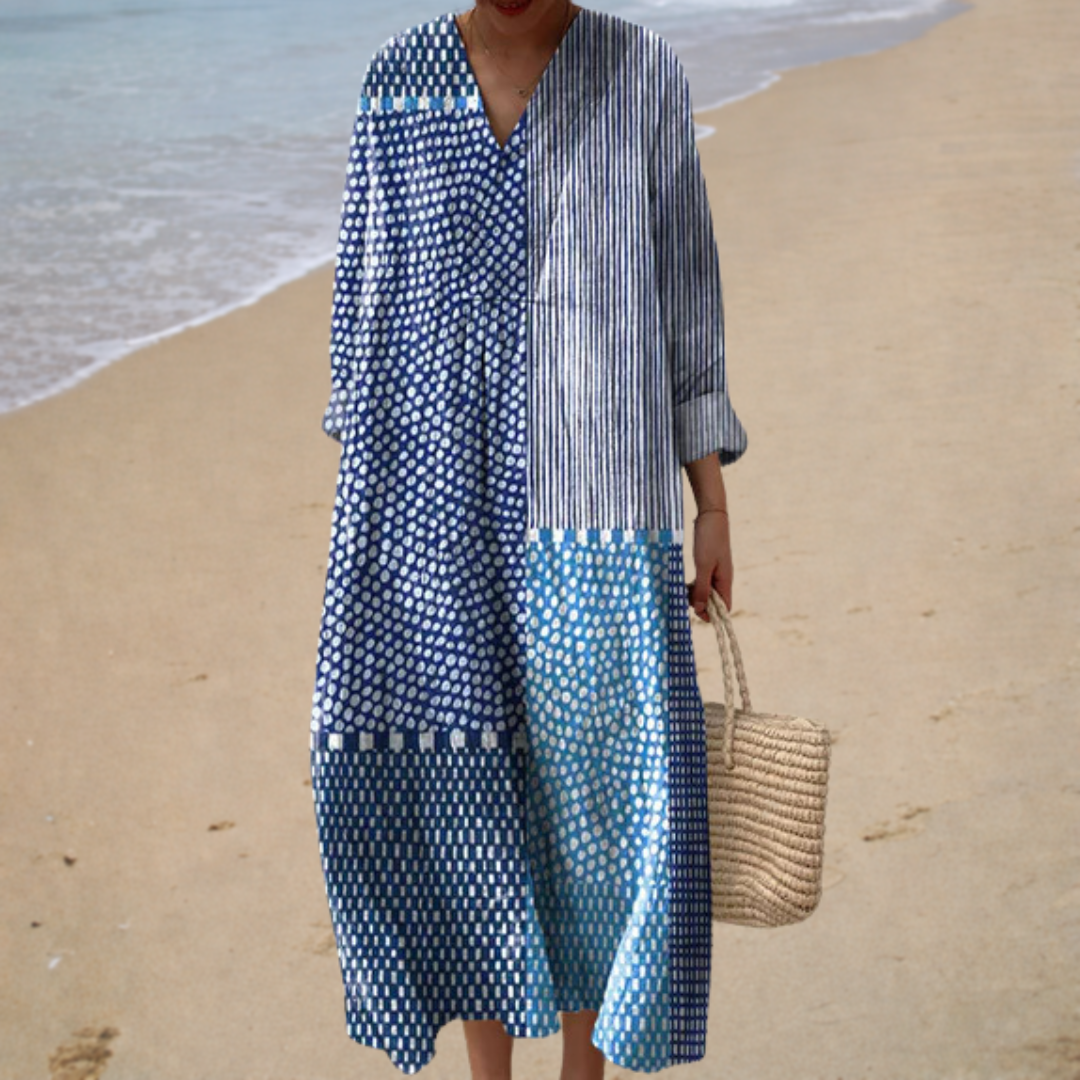 A woman in a softly printed, loose summer dress enjoying a bright summer's day outdoors.