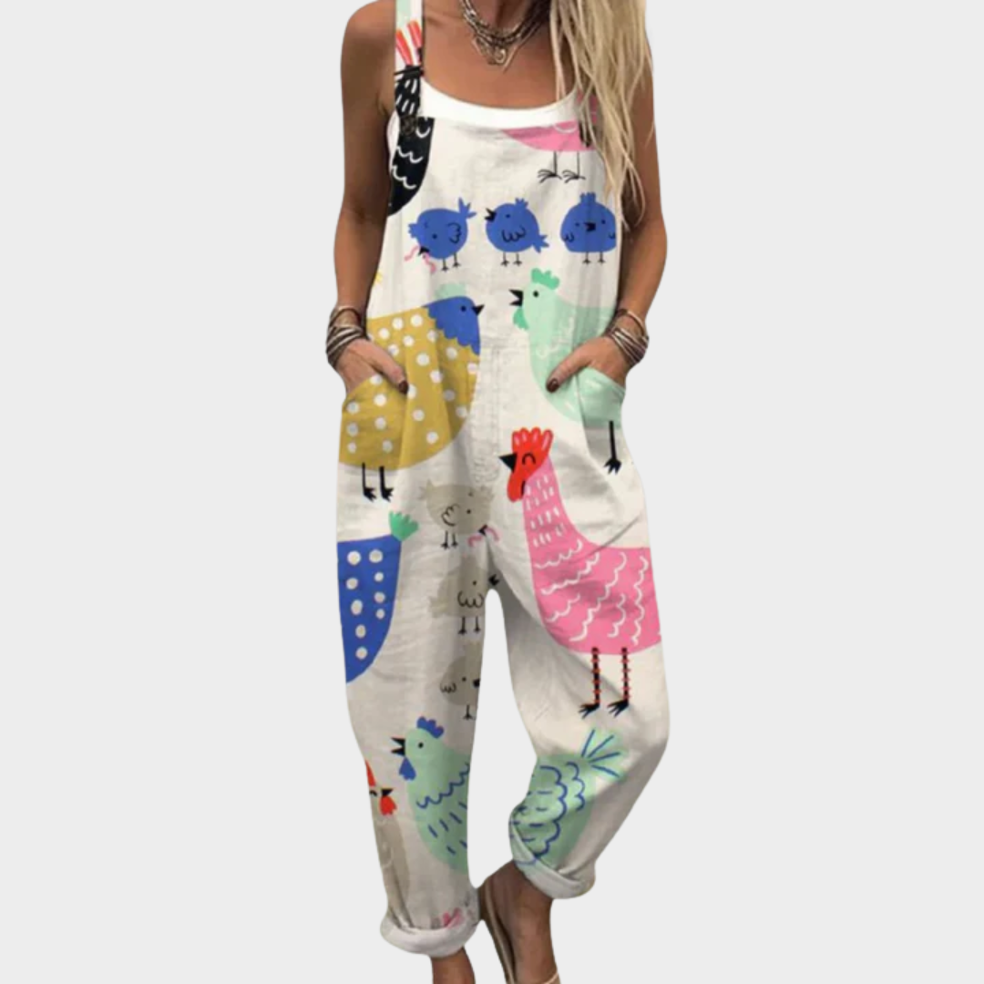 A woman in cream overalls with a cheerful hen and rooster print, relaxed fit and adjustable straps.