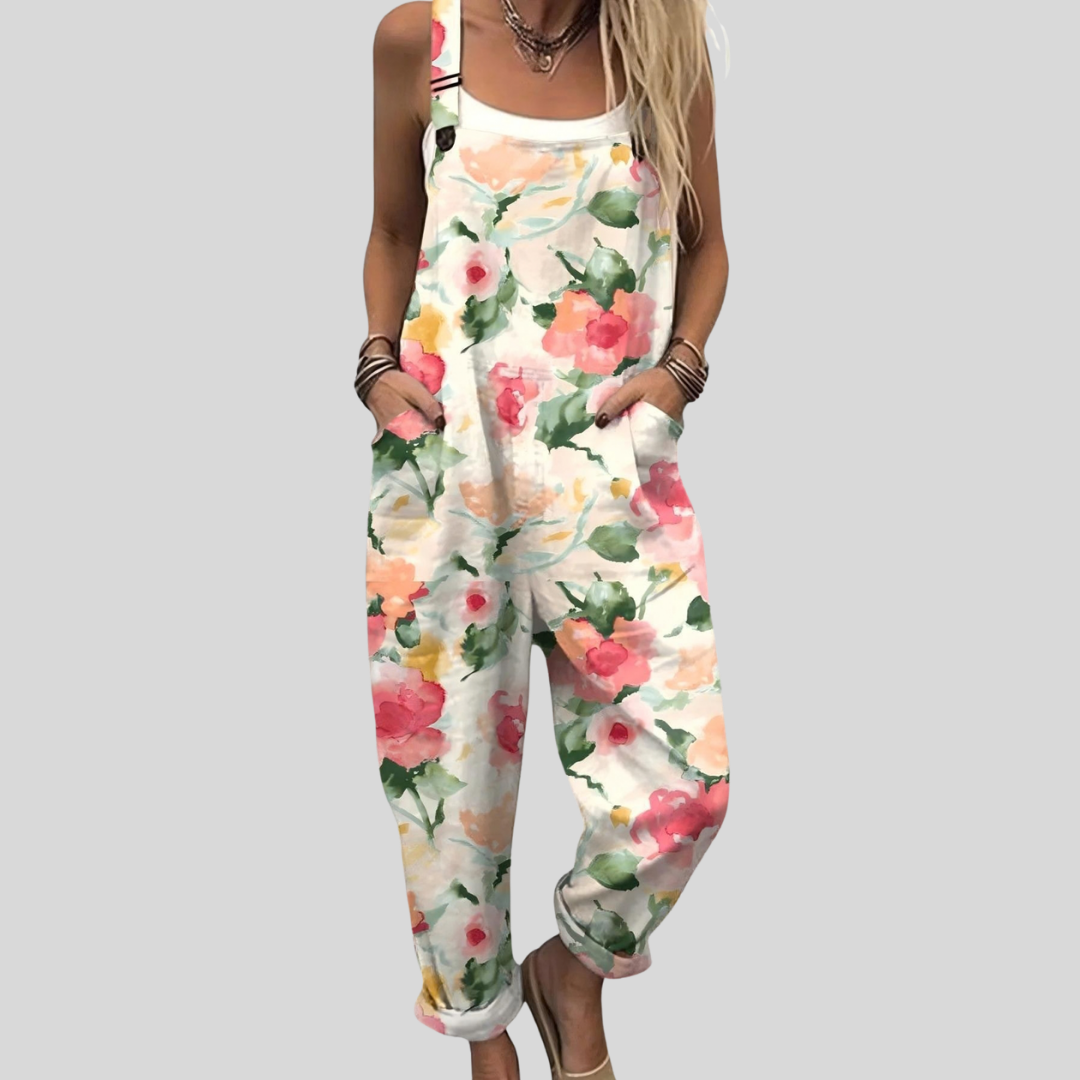 Woman wearing cream overalls with a soft watercolour rose print in pink and peach, relaxed and smiling.