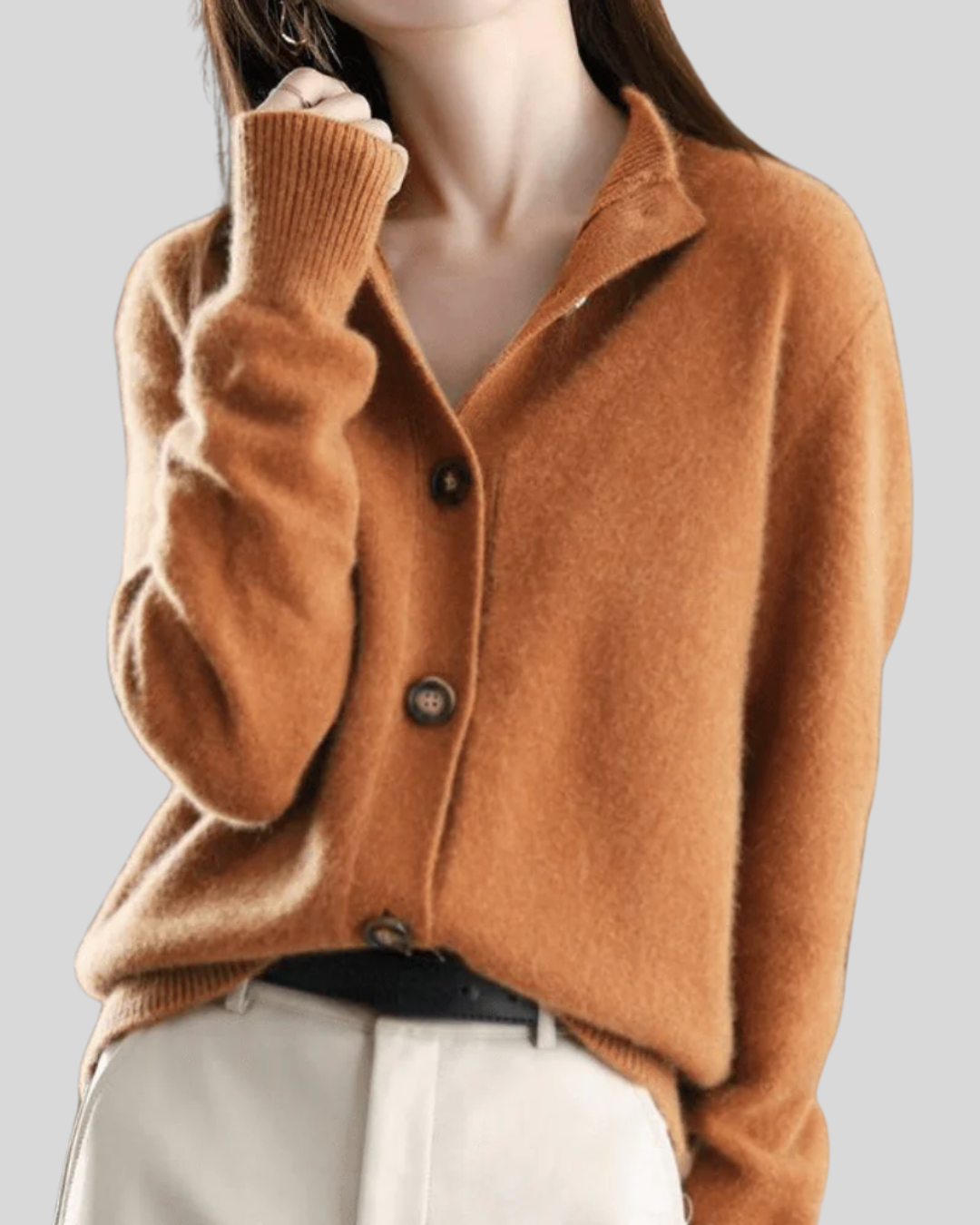 A woman wearing a beige retro button cardigan layered over a dress, warm and elegant.